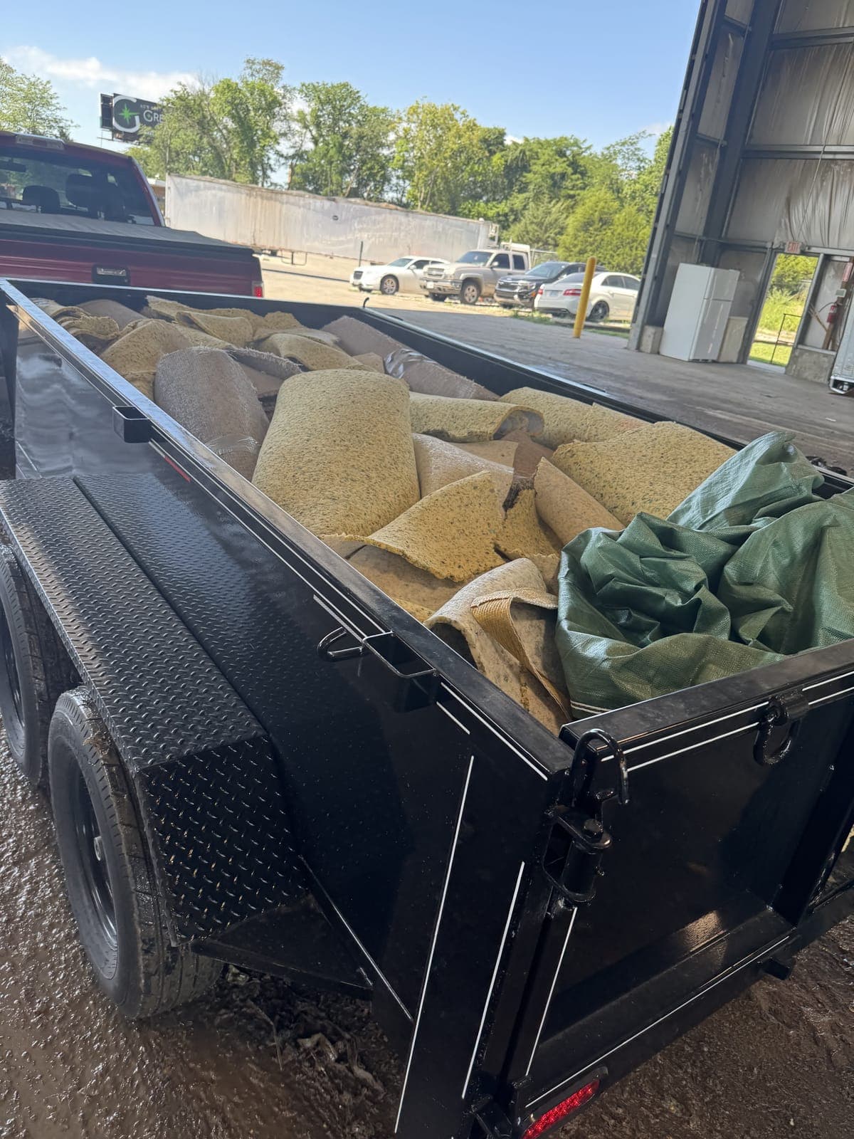 Dump trailer full of torn-out carpet and padding rolls at a Kansas City disposal facility