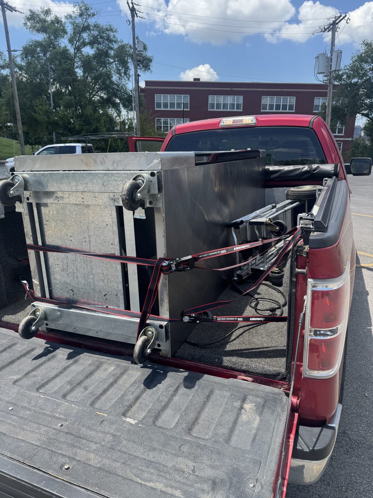 Royal Junk Pros hauling a stainless steel commercial unit strapped down for a commercial junk removal job in the Kansas City metro