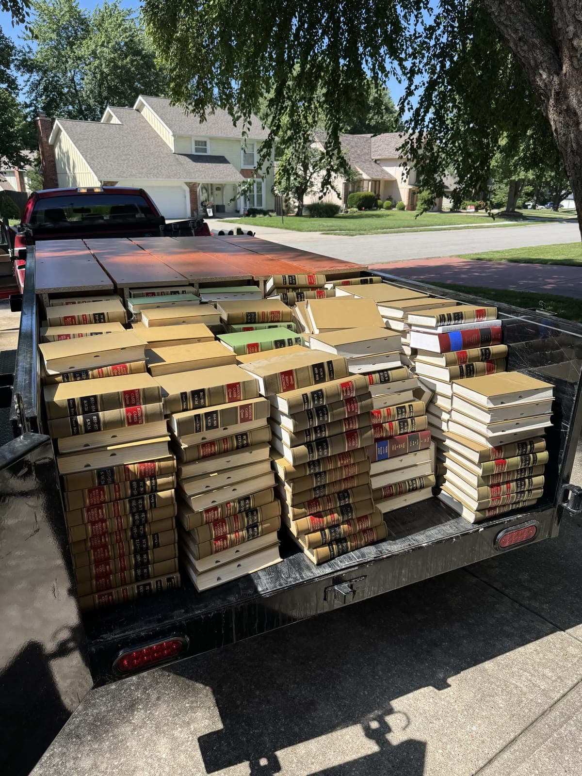 Dump trailer neatly stacked with dozens of old legal reference books from an estate library cleanout in the Kansas City metro